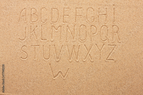 English, German, Portuguese alphabet  written on the sand photo