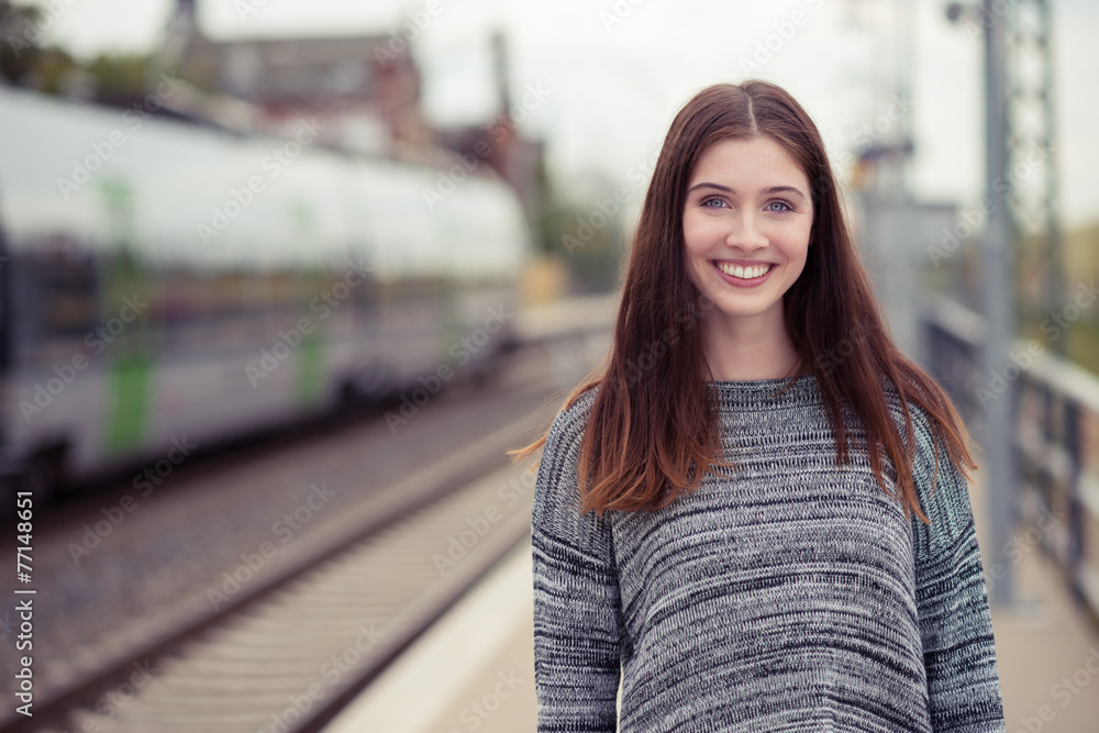 Fototapeta premium lächelnde junge frau am bahnsteig