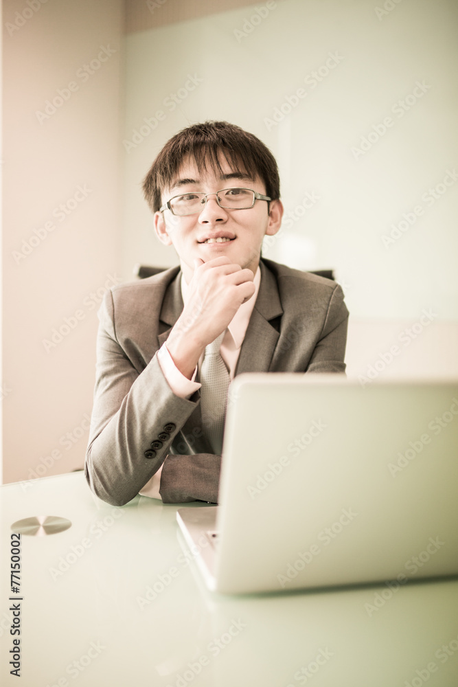 Young handsome man using laptop in his office Young handsome man using laptop in his office
