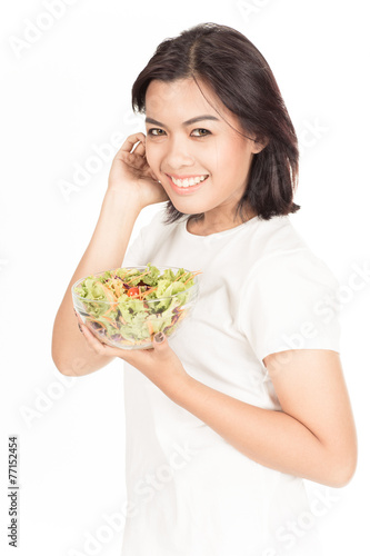 Pretty girl eating fresh vegetable salad
