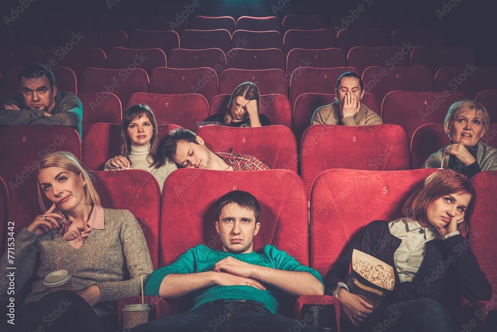 Group of people watching boring movie in cinema Group of people watching boring movie in cinema