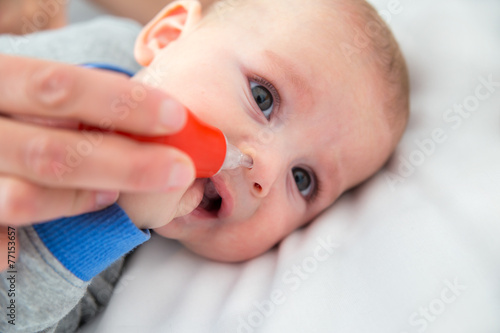 Obraz na płótnie Woman hand cleans baby's nose