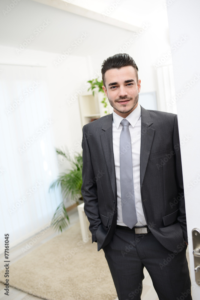 young businessman at the doorway welcoming people young businessman at the doorway welcoming people