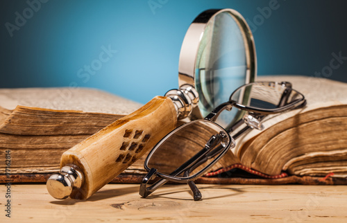 book magnifying glass and glasses on wooden table