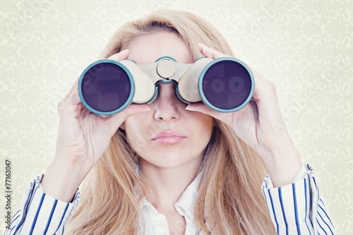 Businesswoman holding binoculars
