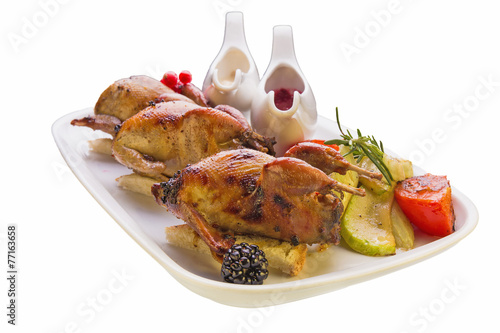 Roasted quail with vegetables on white background
