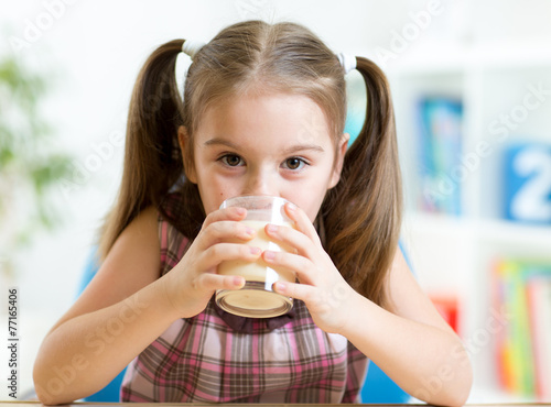 child drinking milk from glass