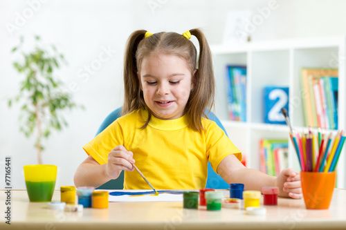 smiling kid painting at home