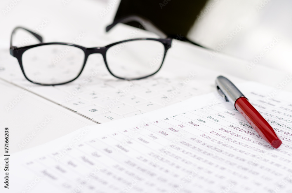 Business composition with laptop glasses pen and statistics shee Business composition with laptop glasses pen and statistics shee