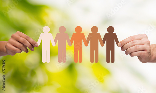 hands holding paper chain multiracial people
