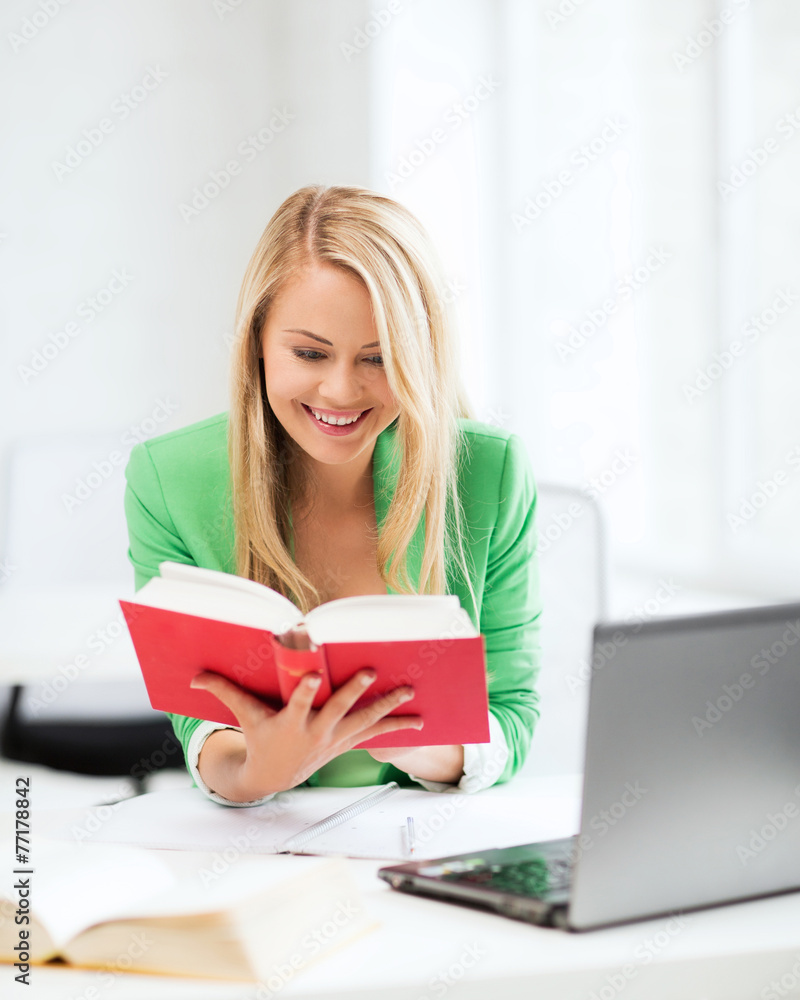 smiling student girl reading book in college smiling student girl reading book in college