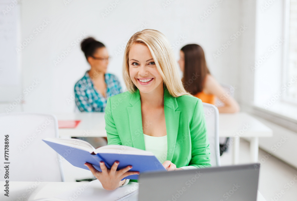 smiling young girl reading book at school smiling young girl reading book at school