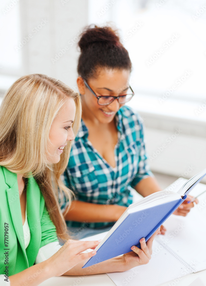 smiling student girls reading book at school smiling student girls reading book at school