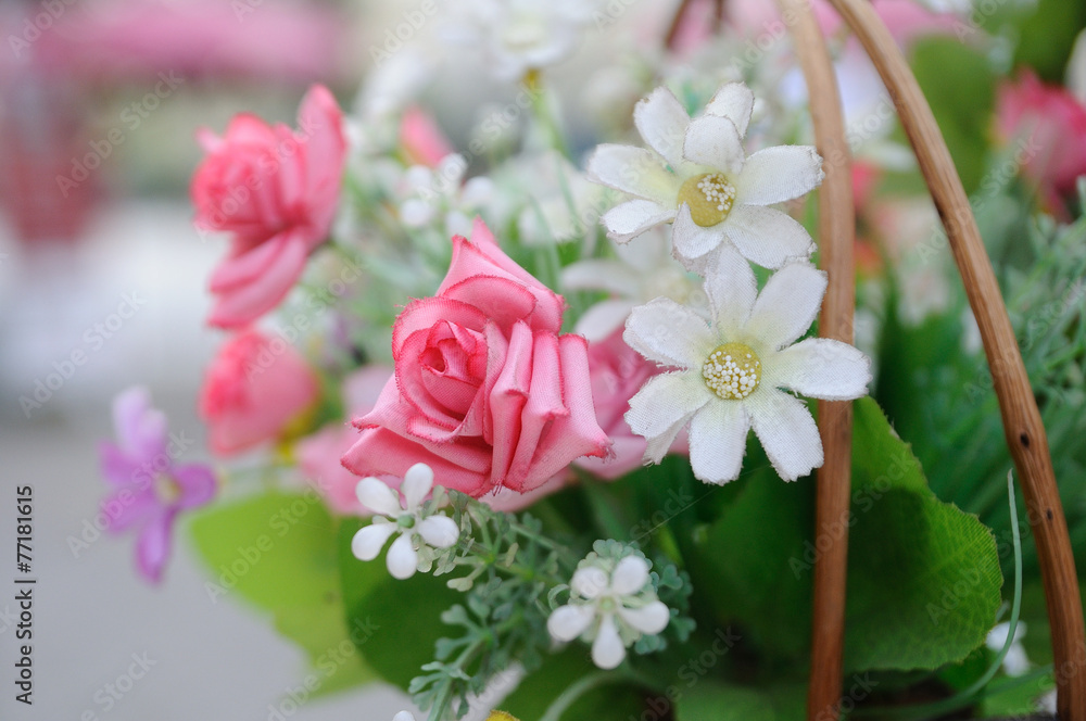 Obraz premium Beautiful flowers in basket hanging aside street.
