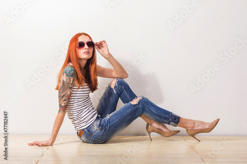 Young red beautiful woman with tattoo and sunglasses