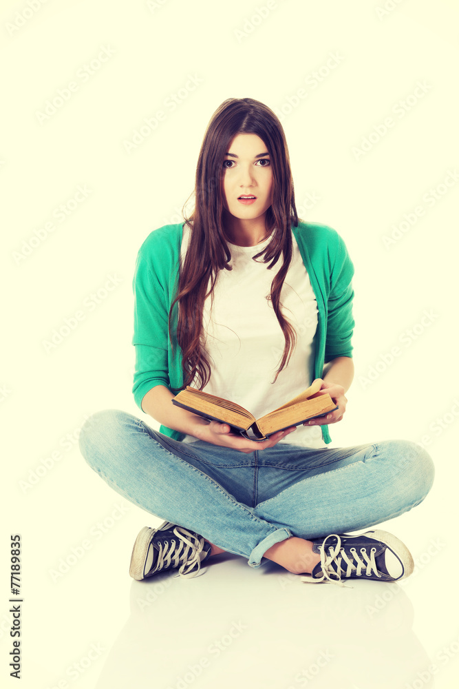 Young woman sitting and reading a book. Young woman sitting and reading a book.