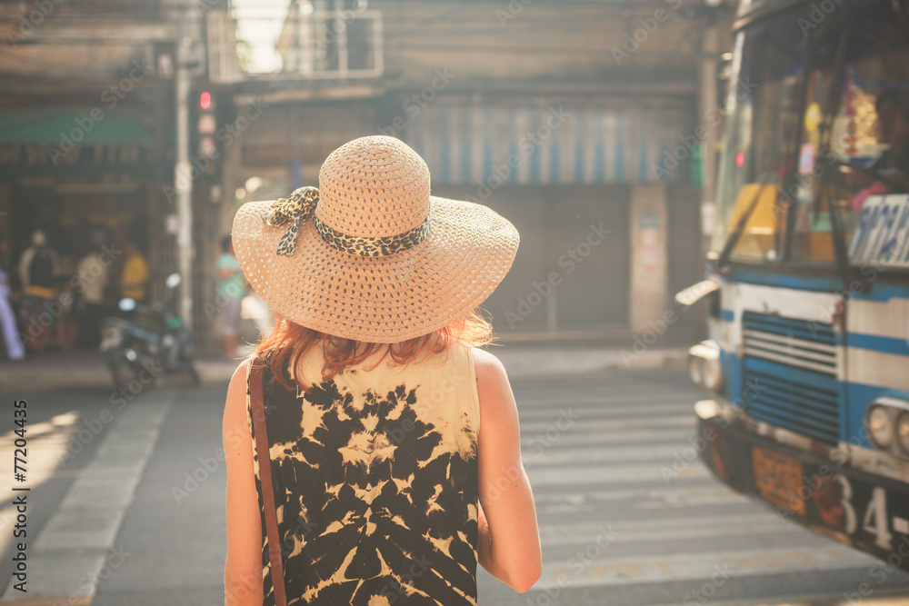 Young woman walking in the street of Asian country