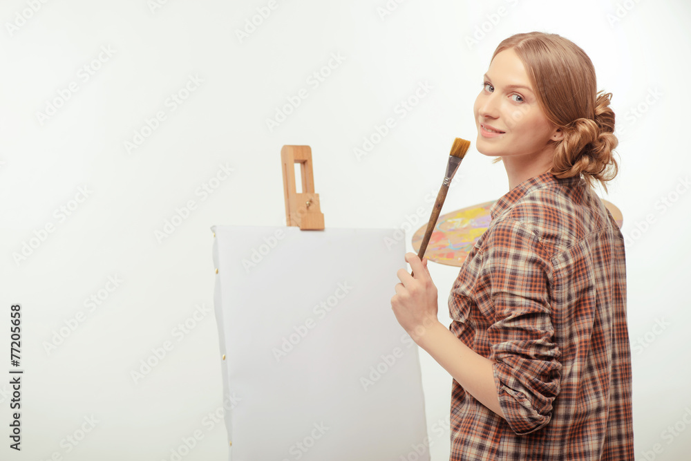 Young beautiful artist posing with a drawing easel and palette Young beautiful artist posing with a drawing easel and palette