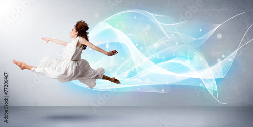 Cute teenager jumping with abstract blue scarf around her