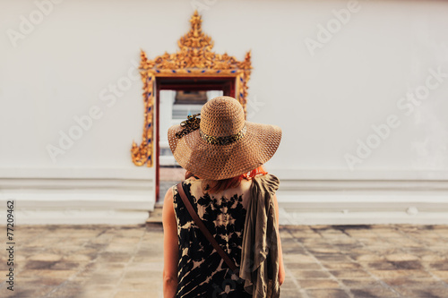Fotografie Woman looking at door to buddhist temple