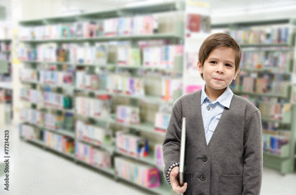 Little boy holding a book in the library Little boy holding a book in the library
