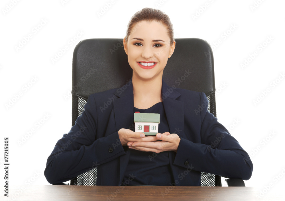 Happy real estate agent, holding a house model Happy real estate agent, holding a house model