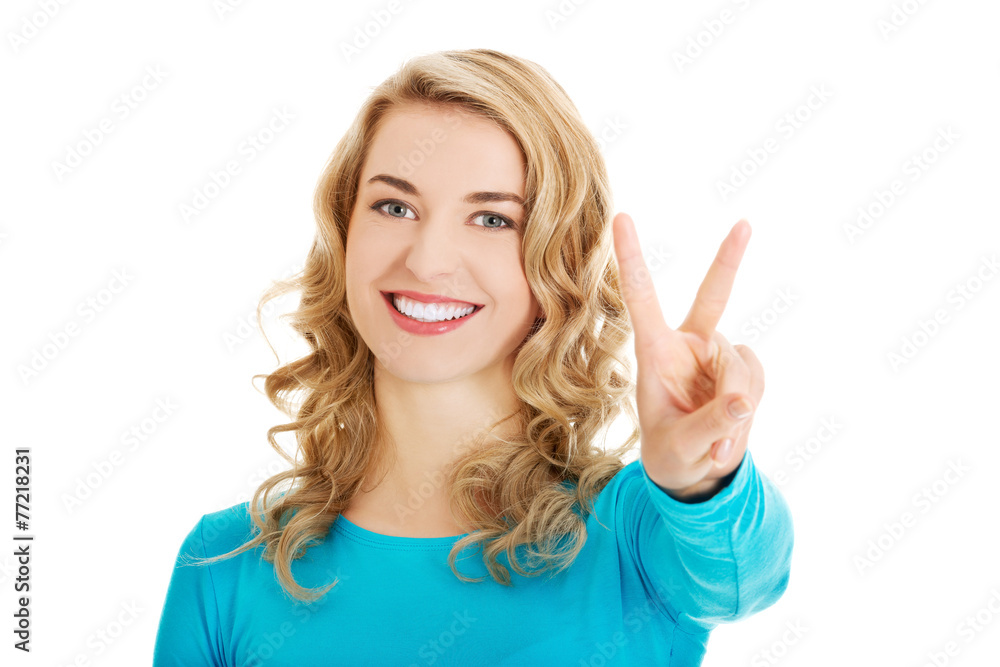 Young woman showing victory sign Young woman showing victory sign