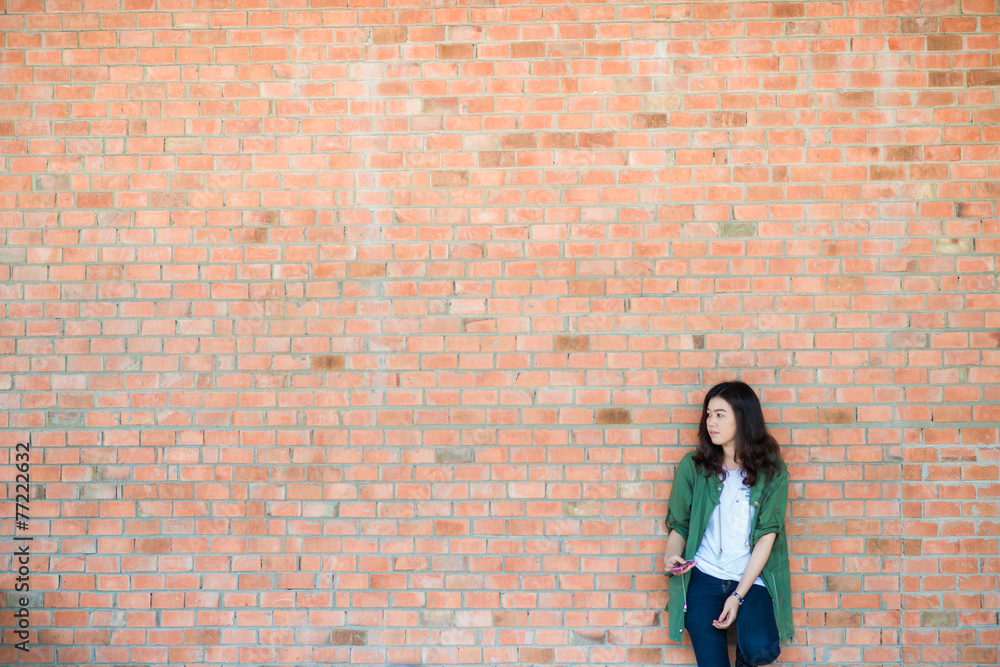 Young asian woman wear green coat stand in front of brick wall b