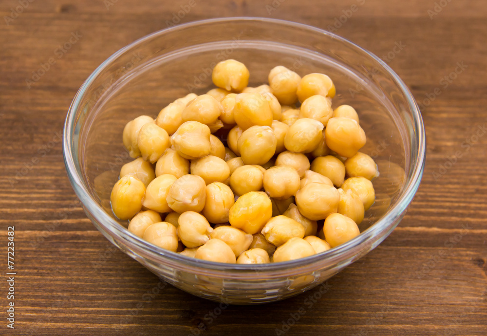 Chickpeas on bowl on wooden table seen from above Chickpeas on bowl on wooden table seen from above
