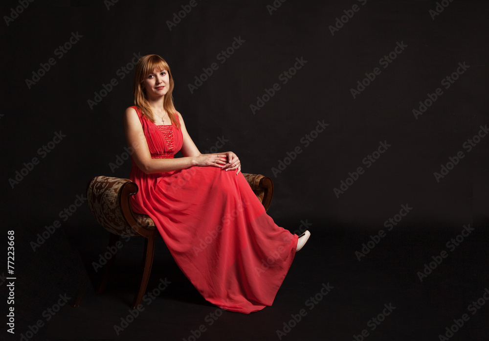 young woman in red dress sitting on a chair young woman in red dress sitting on a chair