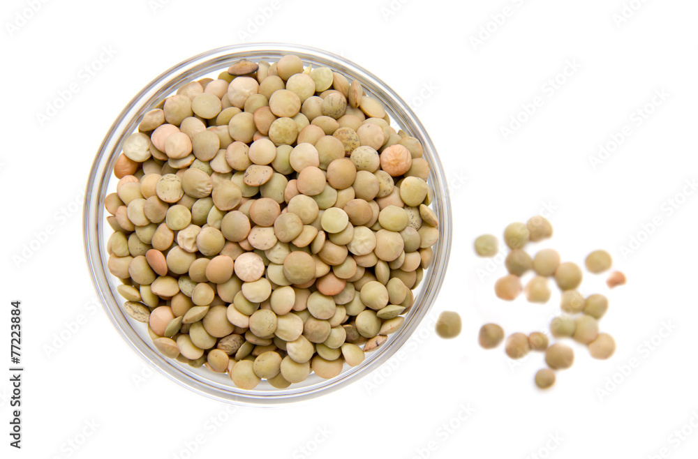 Lentils in glass bowl on white background viewed from above Lentils in glass bowl on white background viewed from above