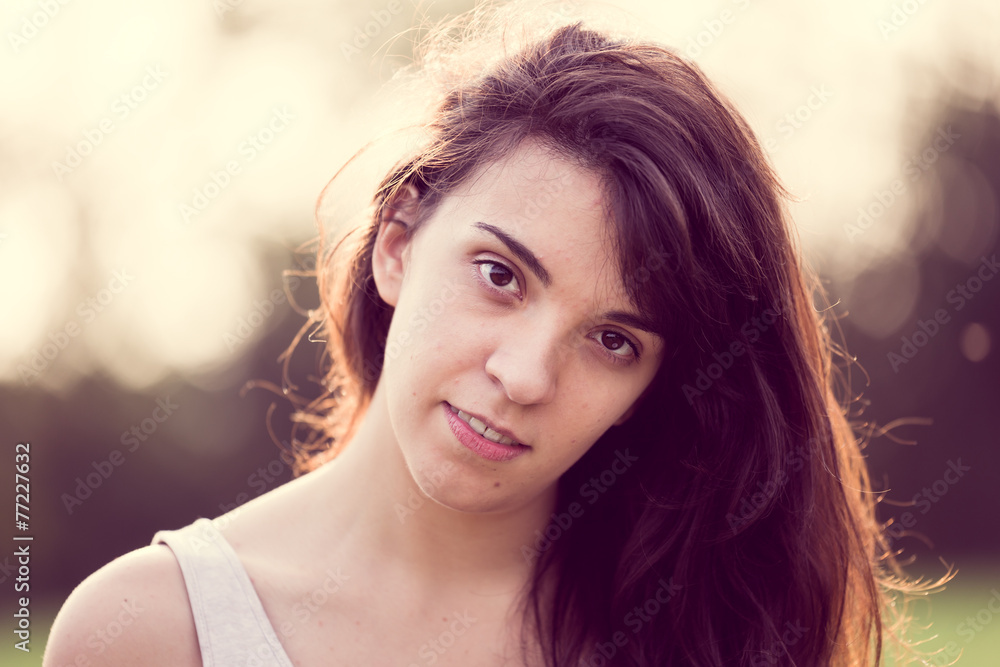 Naklejka premium Beautful young woman looking at you in the garden