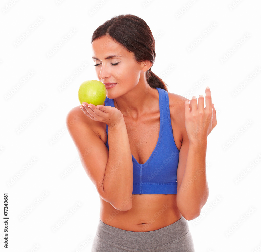 Sporty woman with closed eyes smelling apple Sporty woman with closed eyes smelling apple