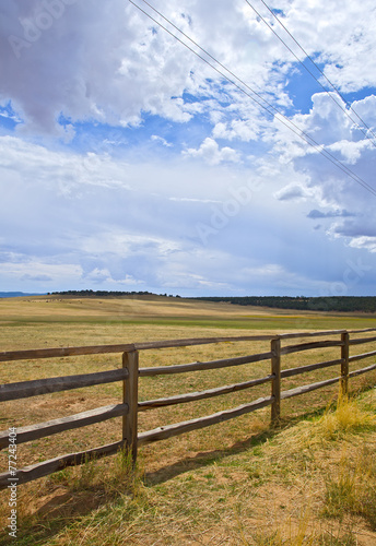 Wooden fence on a rural farm pasture fields