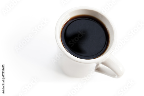 White cup full of black coffee stands on the table