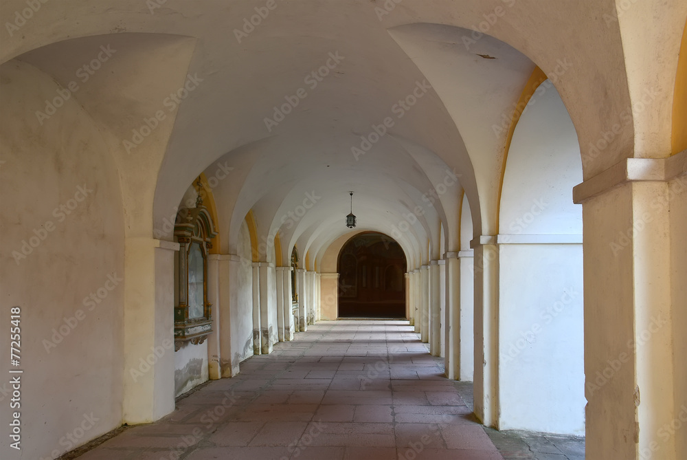 Obraz premium Interior view of the historic cloister walkways at the Swieta Lipka Sanctuary. The rhythmic arches and perspective of the long corridor 