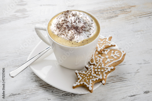 Cup of cappuccino and Christmas  gingerbread on table.