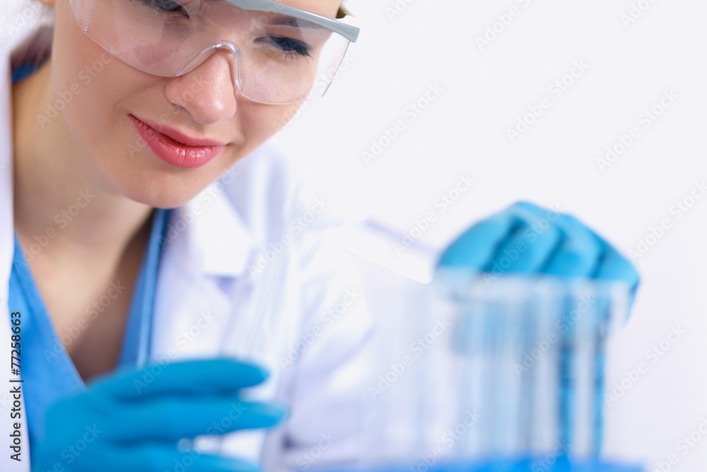 Fototapeta premium Woman researcher is surrounded by medical vials and flasks