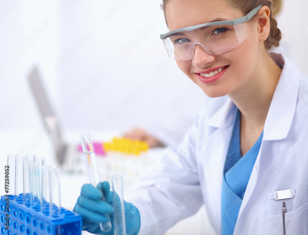 Woman researcher is surrounded by medical vials and flasks Woman researcher is surrounded by medical vials and flasks