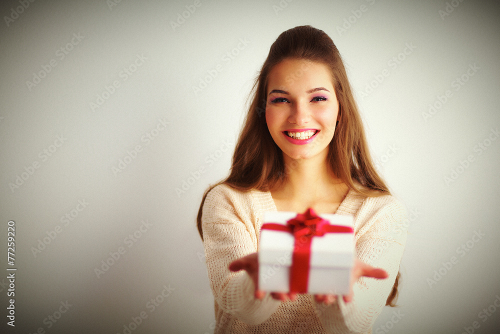 Fototapeta premium Young woman happy smile hold gift box in hands,standing over
