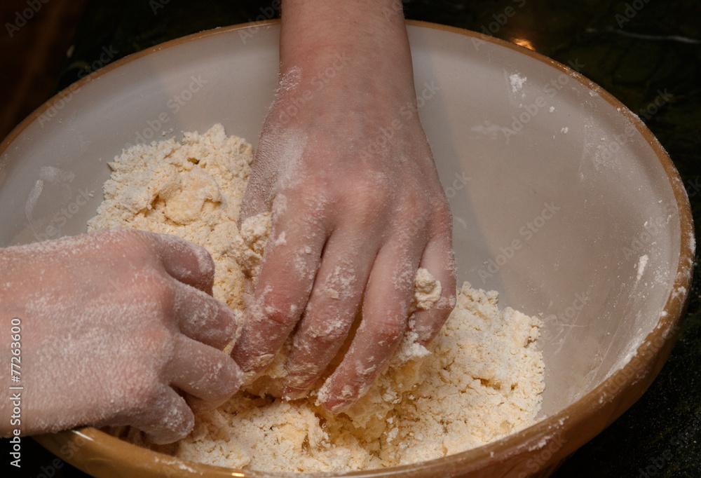 Fototapeta premium Childs hands rubbing flour and other ingredients