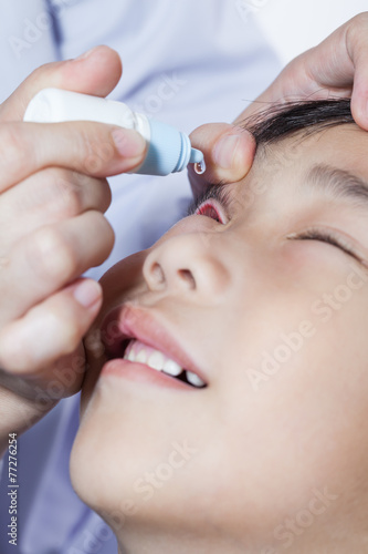Closeup of doctor pouring eye drops in sick children © kdshutterman