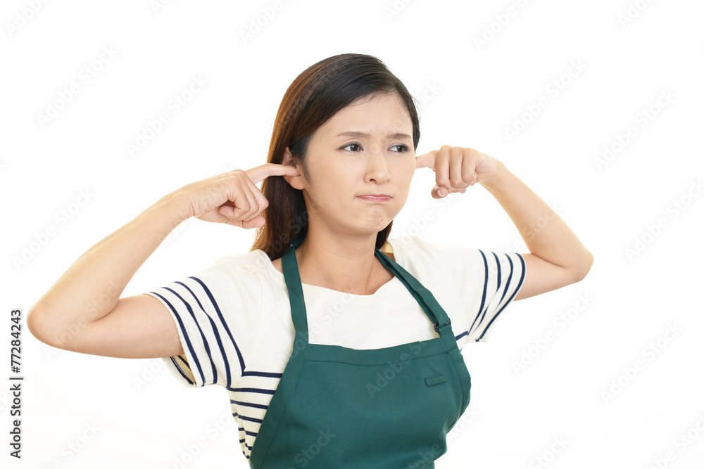 耳を抑える主婦