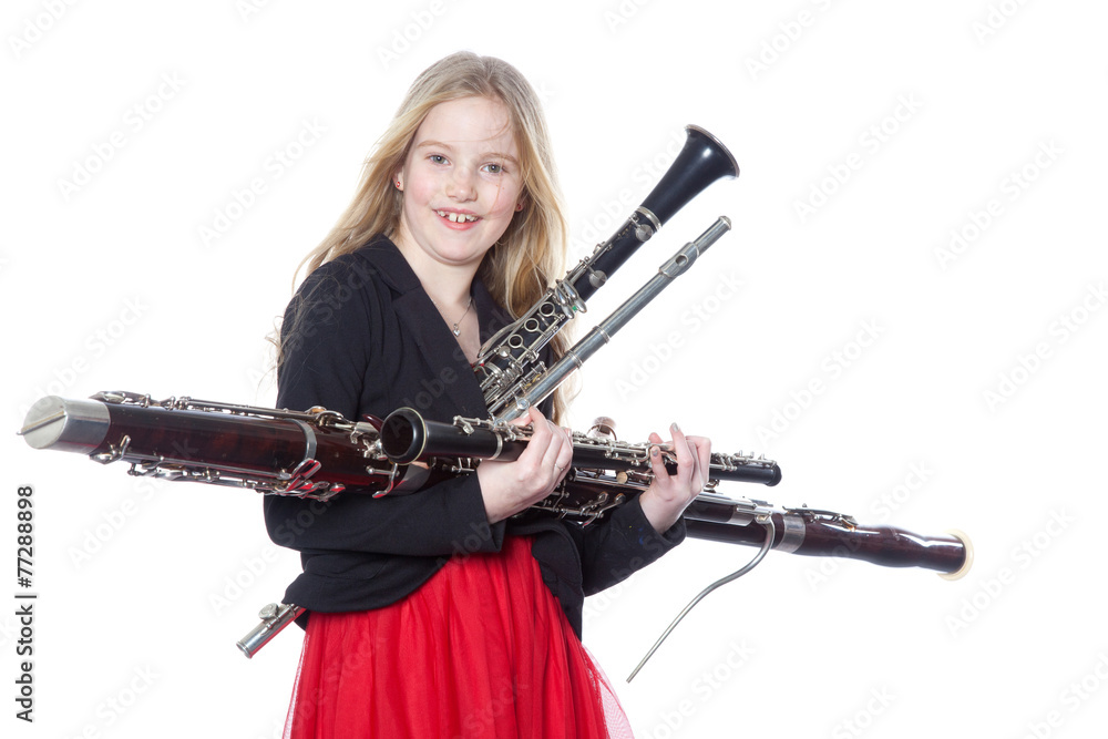 young girl holds woodwind instruments in studio young girl holds woodwind instruments in studio
