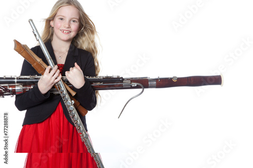 Billede på lærred young girl holds woodwind instruments in studio