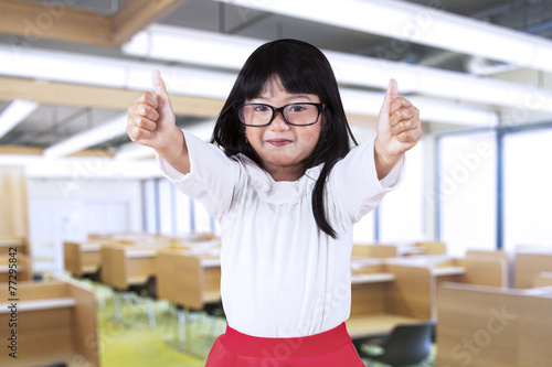 Schoolgirl show thumbs up in class