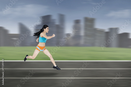 Young woman running outside © Creativa Images
