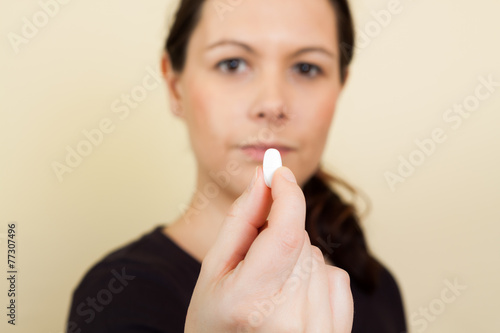 Cropped image of young woman having a pill