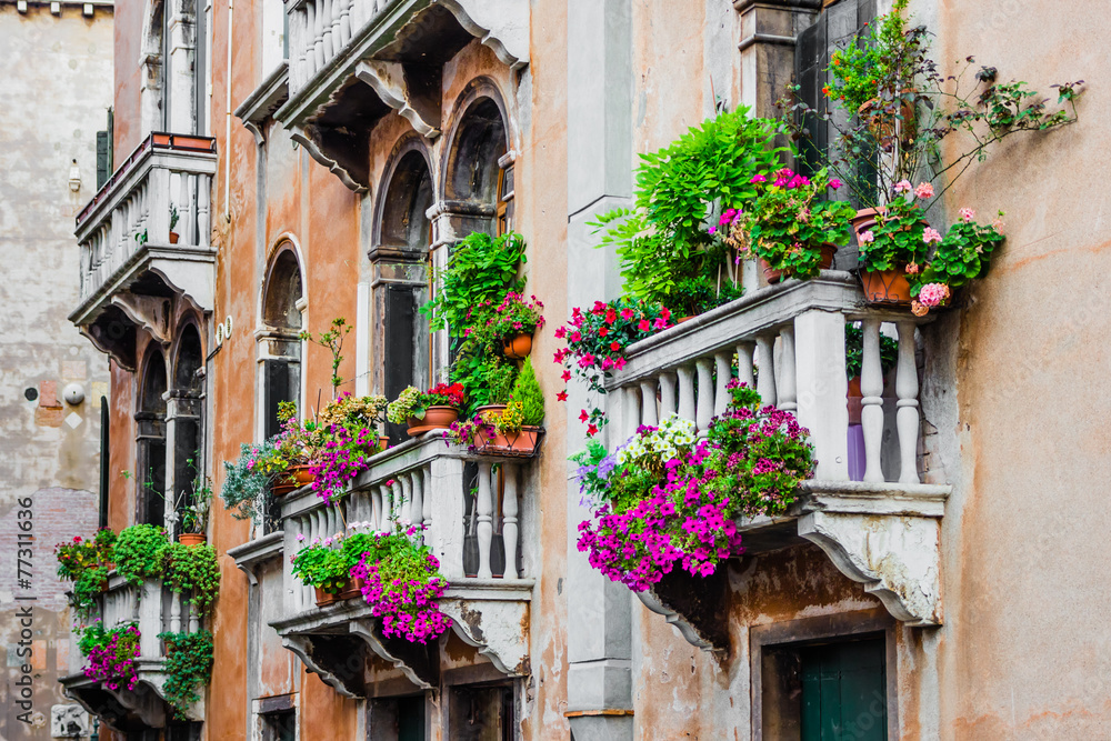Balconies of residential house in Venice decorated with flowers