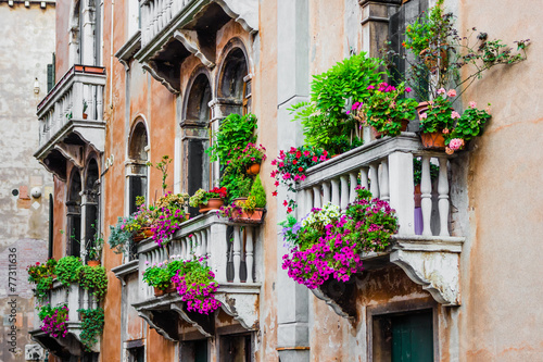 Balconies of residential house in Venice decorated with flowers